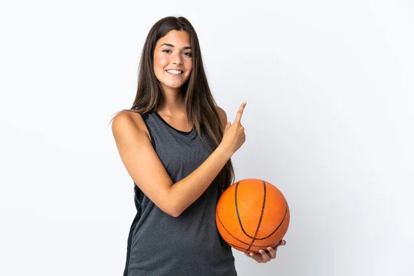 プロダクトを提示するために側面を指す白い背景に隔離されたバスケットボールをしている若いブラジル人女性 — ストック写真