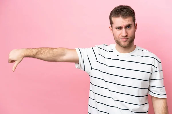 Jonge Blanke Man Geïsoleerd Roze Achtergrond Met Duim Naar Beneden — Stockfoto