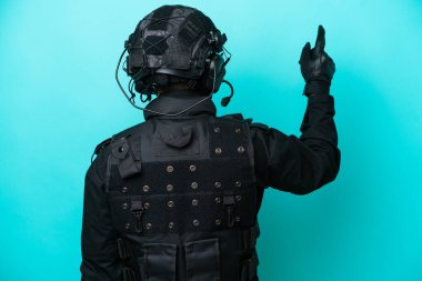 Özel Tim 'in beyaz adamı mavi arka planda izole edilmiş. İşaret parmağıyla işaret ediyor.