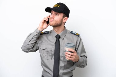 Beyaz arka planda izole edilmiş beyaz güvenlik görevlisi elinde kahve ve cep telefonu var.