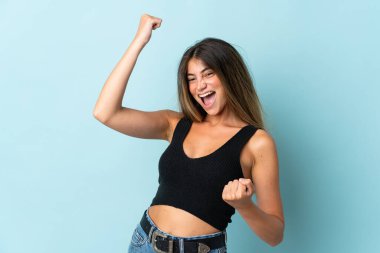 Mavi arka planda izole edilmiş beyaz bir kadın zaferi kutluyor.