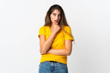 Beyaz arka planda izole edilmiş genç beyaz kadın yukarı bakarken bir fikir düşünüyor.