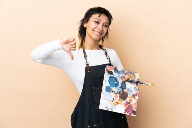 Soyutlanmış arka planda palet tutan genç sanatçı gururlu ve kendini beğenmiş.