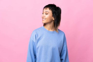 Genç Uruguaylı kadın soyutlanmış pembe arka plan görünümlü