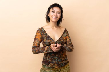 Bej arka planda izole edilmiş Hintli kadın gülüyor