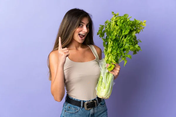 Young Woman Holding Celery Isolated Purple Background Pointing Great Idea — Stock Photo, Image