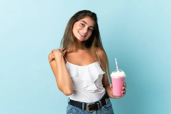 Mujer Joven Con Batido Fresa Aislado Sobre Fondo Azul Riendo —  Fotos de Stock