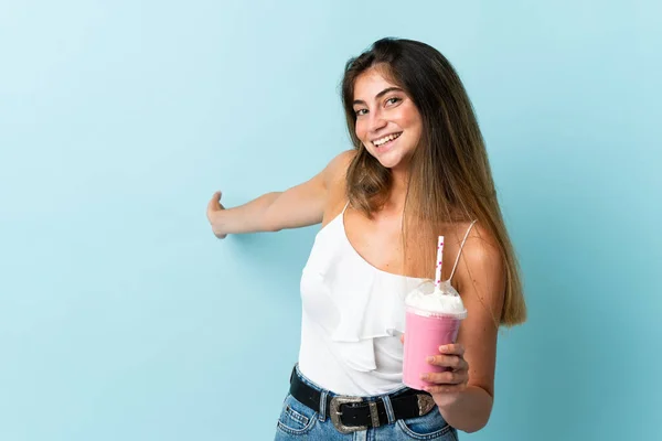 Mujer Joven Con Batido Fresa Aislado Sobre Fondo Azul Extendiendo —  Fotos de Stock