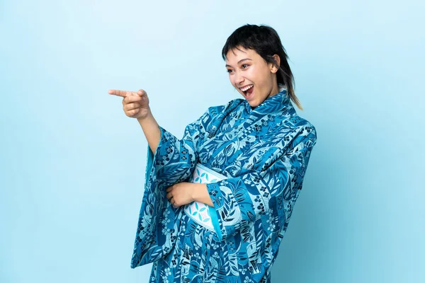 Mujer Joven Con Kimono Sobre Fondo Azul Aislado Apuntando Con —  Fotos de Stock