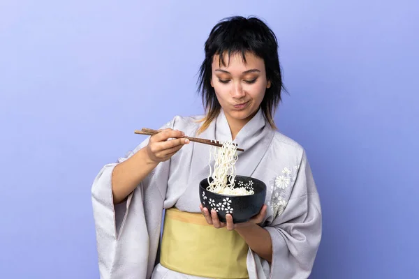 Junge Frau Trägt Kimono Über Isoliertem Blauem Hintergrund Und Hält — Stockfoto