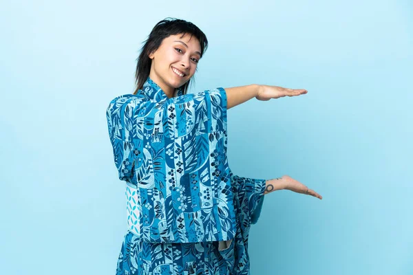 Mujer Joven Usando Kimono Sobre Fondo Azul Aislado Sosteniendo Espacio —  Fotos de Stock