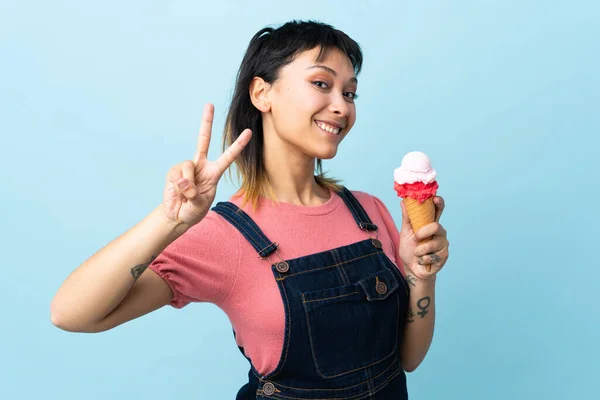 Jovem Uruguaia Segurando Sorvete Corneta Sobre Fundo Azul Isolado Sorrindo — Fotografia de Stock