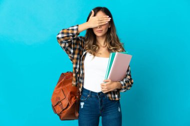 Mavi arka planda, gözleri elleriyle kapatan genç bir kız öğrenci. Bir şey görmek istemiyorum.