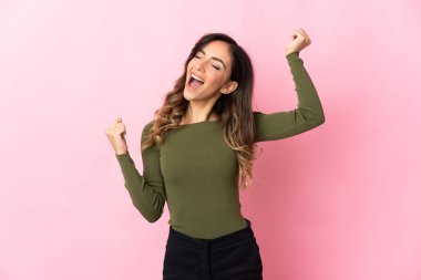 Pembe arka planda izole edilmiş beyaz bir kadın zaferi kutluyor.