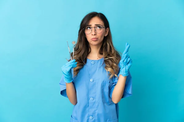 Zahnärztin Hält Werkzeug Über Isoliert Auf Blauem Hintergrund Mit Daumendrücken — Stockfoto