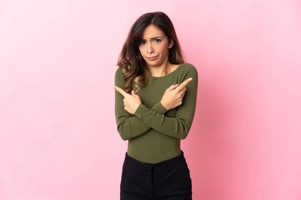 Mujer Joven Caucásica Aislada Sobre Fondo Rosa Apuntando Los Laterales — Foto de Stock