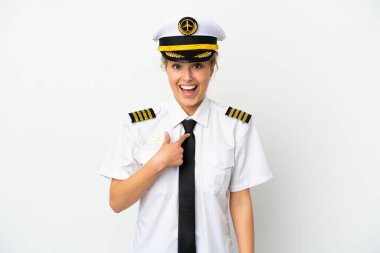 Uçaktaki sarışın kadın pilot, beyaz arka planda, sürpriz bir yüz ifadesiyle izole edilmiş.