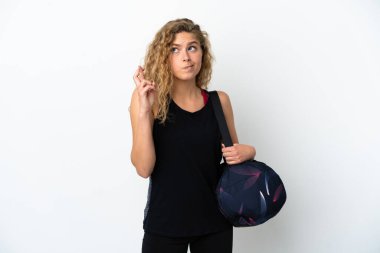 Spor çantalı genç bayan beyaz arka planda izole edilmiş, parmakları çapraz ve en iyisini diliyor.