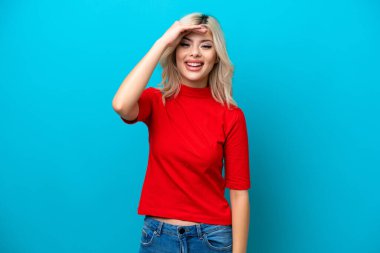 Mavi arka planda izole edilmiş genç bir Rus kadın. Bir şeye bakmak için çok uzaklara bakıyor.