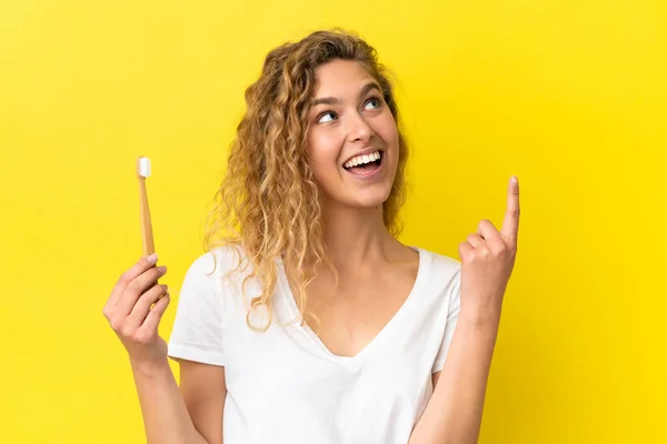 Νεαρή Λευκή Γυναίκα Που Κρατάει Ένα Βουρτσισμένο Δόντι Απομονωμένο Κίτρινο — Φωτογραφία Αρχείου