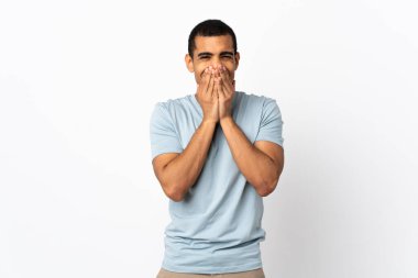 İzole edilmiş beyaz arka planda yaşayan Afrikalı Amerikalı adam mutlu ve gülümsüyor elleriyle ağzını kapatıyor.