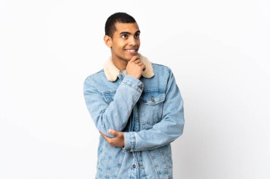 Afrika kökenli beyaz bir adam gülümserken yukarı bakıyor.