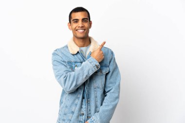 İzole edilmiş beyaz arka planı olan Afrikalı Amerikalı bir adam bir ürün sunmak için kenarı işaret ediyor.