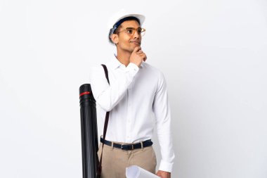 Miğferi olan ve elinde izole edilmiş beyaz arkaplan üzerinde planlar tutan Afrikalı Amerikalı mimar bir fikir ararken