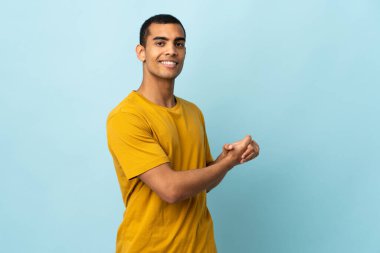 Afrika kökenli Amerikalı adam alkışlıyor.