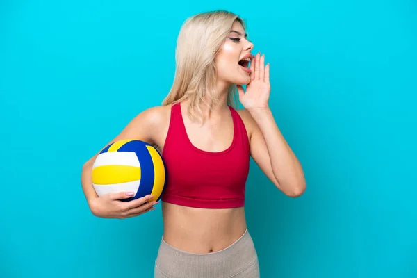 年轻的俄罗斯女子打排球时 被蓝色背景隔离 大嗓门张大 侧边大喊 — 图库照片