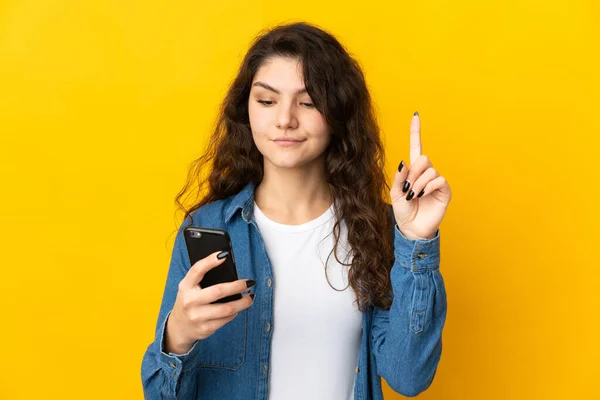 Έφηβη Ρωσίδα Απομονωμένη Κίτρινο Φόντο Χρησιμοποιώντας Κινητό Τηλέφωνο Και Σηκώνοντας — Φωτογραφία Αρχείου