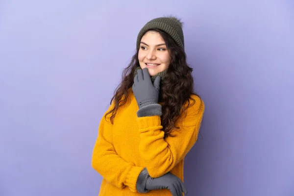 俄罗斯少女 头戴冬帽 背景紫色 面带微笑抬头看人 — 图库照片