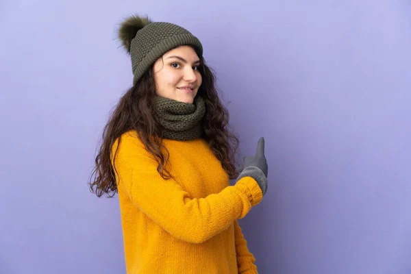 Tonåring Ryska Flicka Med Vinter Hatt Isolerad Lila Bakgrund Pekar — Stockfoto