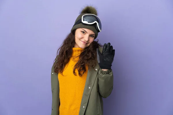 俄罗斯少女 戴着雪板眼镜 与紫色背景隔离 手牵着手愉快地打招呼 — 图库照片