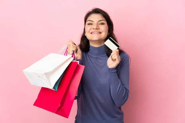 Tiener Russisch Meisje Geïsoleerd Roze Achtergrond Holding Boodschappentassen Een Creditcard — Stockfoto