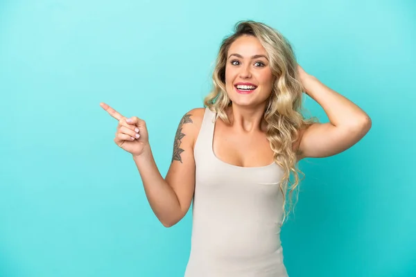 Young Brazilian Woman Isolated Blue Background Surprised Pointing Finger Side — Foto Stock