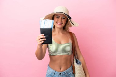 Yaz tatilinde mayo giymiş genç Brezilyalı kadın pembe arka planda mutlu bir ifadeyle izole edilmiş.