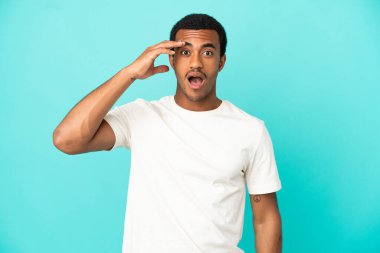 İzole edilmiş mavi arka plandaki Afro-Amerikan yakışıklı adam bir şey fark etti ve çözüme niyetlendi.