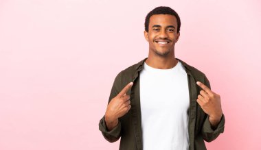 Telif uzayındaki Afro-Amerikalı adam pembe arka planda baş parmak hareketi yapıyor.