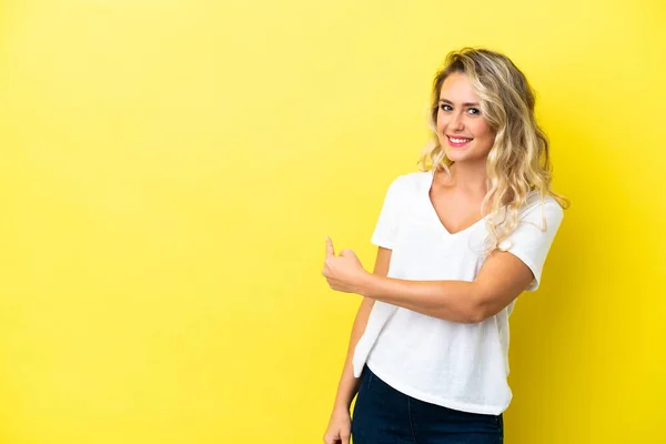 Mujer Brasileña Joven Aislada Sobre Fondo Amarillo Apuntando Hacia Atrás —  Fotos de Stock