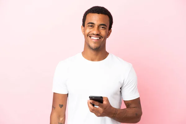 Afroamerykanin Przystojny Mężczyzna Odizolowanym Różowym Tle Pomocą Telefonu Komórkowego — Zdjęcie stockowe