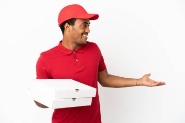 Afro-Amerikalı pizza teslimatçısı, beyaz duvarın üzerinden pizza kutuları topluyor.