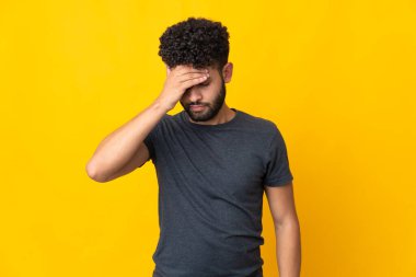 Faslı genç bir adam sarı arka planda izole edilmiş, baş ağrısı var.