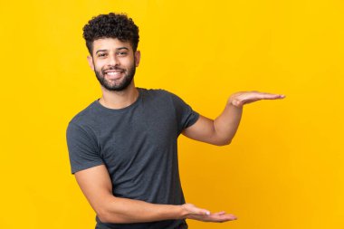 Faslı genç bir adam sarı arka planda izole edilmiş. Kopyalama alanı var.