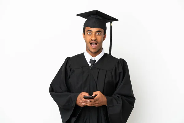 Afroamerikanische Universitätsabsolvent Mann Über Isolierten Weißen Hintergrund Überrascht Und Sendet — Stockfoto
