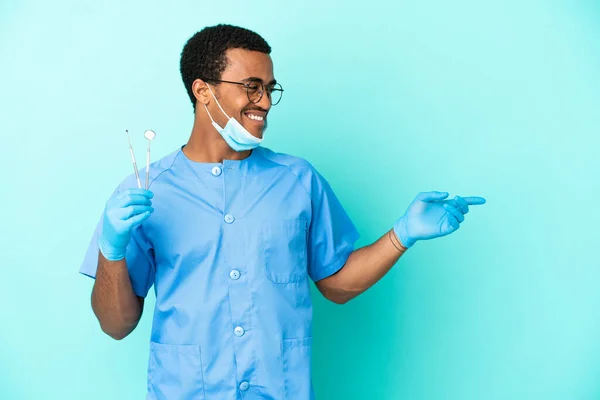 Africano Dentista Americano Segurando Ferramentas Sobre Fundo Azul Isolado Apontando — Fotografia de Stock