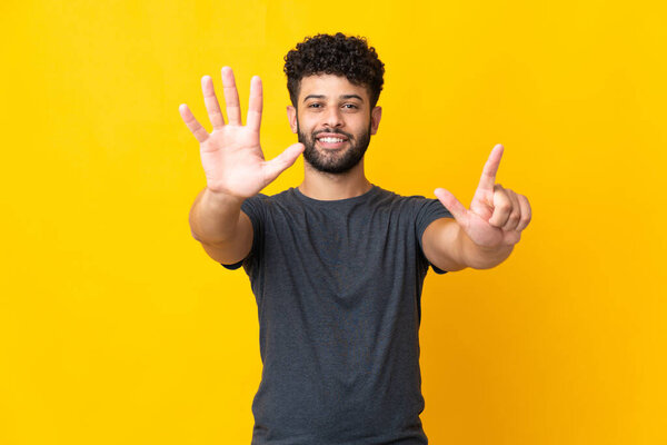 Young Moroccan man isolated on yellow background counting seven with fingers