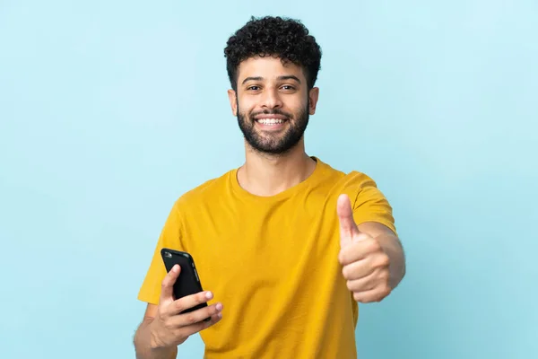 Genç Faslı Adam Mavi Arka Planda Izole Edilmiş Cep Telefonu — Stok fotoğraf