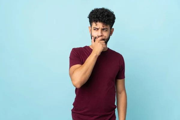 Joven Hombre Marroquí Aislado Sobre Fondo Azul Que Tiene Dudas — Foto de Stock