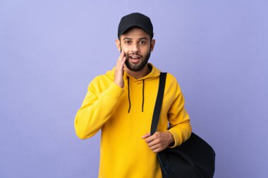 Spor çantalı genç Fas 'lı adam mor arka planda şaşırmış ve şok olmuş bir yüz ifadesiyle izole edilmiş.